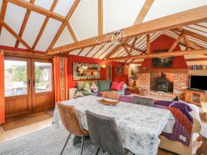 een woonkamer met een tafel en een open haard bij The Lodge in Norwich