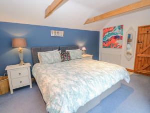 a bedroom with a bed and a blue wall at The Lodge in Norwich