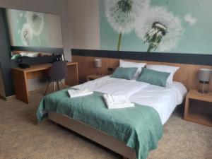 a bedroom with a large bed and a desk with a chair at HOTEL PORT 2000 Torzym in Torzym