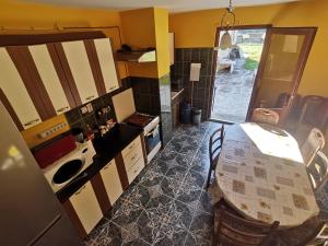 a kitchen with a table and a refrigerator and a door at Casa LUCA in Luncasprie