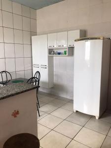 a kitchen with a white refrigerator and a table at Espaço Magalhães in Barra do Garças