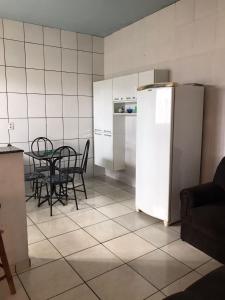 eine Küche mit einem Tisch und einem weißen Kühlschrank in der Unterkunft Espaço Magalhães in Barra do Garças
