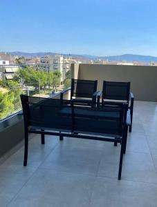 a bench on a balcony with a view of a city at Eleusis Luxury Flat,car park in property in Eleusis +12 photos