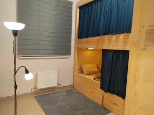 a bedroom with a bunk bed with a blue curtain at Hostel Riga KVANT in Rīga