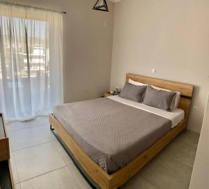 a bedroom with a bed and a large window at Eleusis Luxury Flat,car park in property in Eleusis