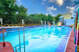 a large swimming pool with a slide and a playground at Swad Ri Dhani, Ajmer in Ajmer