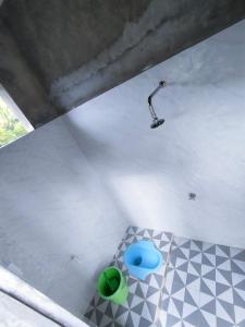 Zimmer mit Dusche und blauem Objekt auf dem Boden in der Unterkunft Rumah Gadang Simarasok in Baso