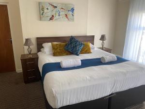 a bedroom with a large bed with pillows on it at The New Brighton Hotel in New Brighton