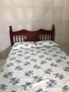 a bed with a blue and white comforter at Espaço Magalhães in Barra do Garças