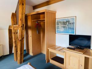 a room with a bed and a tv and a desk at Hotel Sternen Worb in Worb