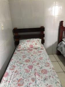 niewielka sypialnia z łóżkiem z narzutą kwiatową w obiekcie Espaço Magalhães w mieście Barra do Garças