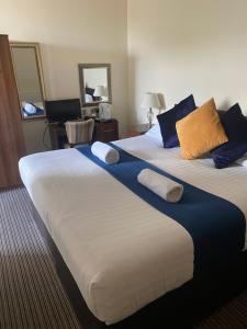 two beds in a hotel room with towels on them at The New Brighton Hotel in New Brighton