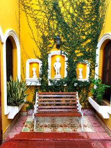 un banco sentado frente a un edificio amarillo en Casa del Agua, en Granada