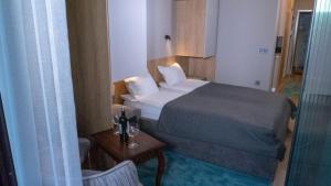 a small bedroom with a bed and a table with a bottle of wine at Луксозно студио One Place in Sofia А2 - Лозенец in Sofia