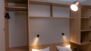 a bedroom with wooden shelves and a bed with white pillows at Луксозно студио One Place in Sofia А2 - Лозенец in Sofia