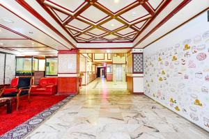 a lobby with a red couch and a wall with stickers at OYO 119 Le Vondome in Manama