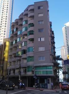 un edificio alto en una calle de la ciudad con coches en Lindo apartamento Avenida Brasil, en Balneário Camboriú