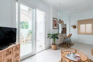 salon z telewizorem i stołem w obiekcie Oasis con patio y encanto en centro Sevilla w Sewilli