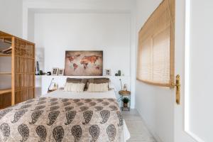 sypialnia z łóżkiem i obrazem na ścianie w obiekcie Oasis con patio y encanto en centro Sevilla w Sewilli