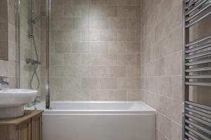 a bathroom with a bath tub and a sink at Pass the Keys NEW Chic 2 Bed Pad Central Free Parking in Birmingham