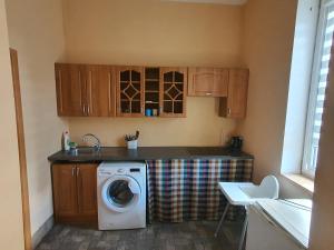 a kitchen with a washing machine and a sink at Vecais cels 25C in Jelgava
