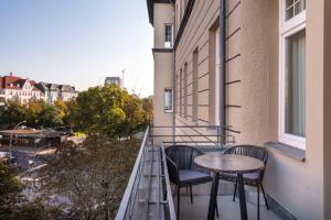 a balcony with two chairs and a table on a building at numa I Novela Rooms & Apartments in Berlin
