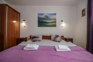 a bedroom with a purple bed with two pillows on it at Apartments Millenium in Žabljak