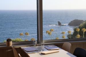 a table in a restaurant with a view of the ocean at Housel Bay Hotel in Lizard
