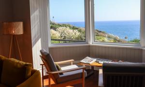 a living room with a table and a view of the ocean at Housel Bay Hotel in Lizard