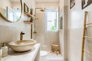 uma casa de banho com um lavatório de pedra e um espelho. em Oasis con patio y encanto en centro Sevilla em Sevilha