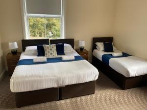 a bedroom with two beds and a window at The New Brighton Hotel in New Brighton