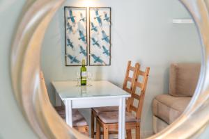 a table with a bottle of wine and two chairs at St Nicholas B8 Beach Studio I in Dafnila