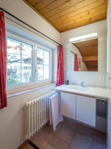 uma casa de banho com um lavatório e uma janela em Haus Wick em Klosters Serneus