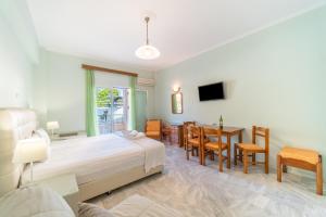 a bedroom with a bed and a table and chairs at St Nicholas B4 Beach Garden View I in Dafnila