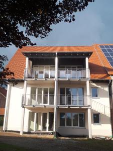 Hof Schütterle في فريدريشسهافن: مبنى مع شرفة وسقف مع الالواح الشمسية