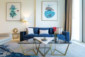 a living room with a blue couch and a coffee table at Exquisite Apartment Minutes Away from the Beach in Dubai