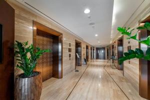 a hallway in a building with wooden walls and a plant at Exquisite Apartment Minutes Away from the Beach in Dubai