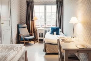 a hotel room with a bed and a desk and a window at Rimforsa Strand in Rimforsa