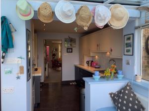 Kent的住宿－Magical, Stylish, Comfortable, Brilliant Location，厨房设有挂在天花板上的稻草帽