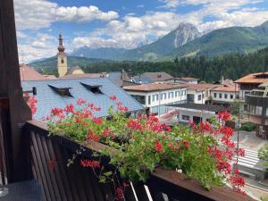 a view of a town with flowers on a balcony at Hotel Nevada in Tarvisio