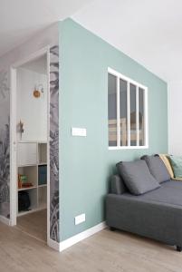 salon z kanapą i dużym lustrem w obiekcie Bandol AZUR - 2 chambres, balcon, bord de mer, wifi, climatisé et parking privé w mieście Bandol