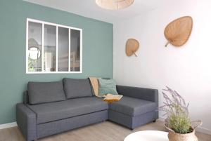 salon z kanapą i oknem w obiekcie Bandol AZUR - 2 chambres, balcon, bord de mer, wifi, climatisé et parking privé w mieście Bandol