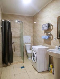 y baño con ducha, aseo y lavamanos. en Rusel Hotel en Aktau