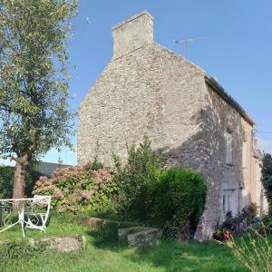 un vecchio edificio in pietra con una sedia davanti di Maison Cancale Port-Mer a Cancale