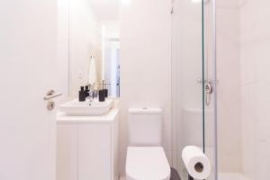 La salle de bains blanche est pourvue de toilettes et d'un lavabo. dans l'établissement Oporto Near Deluxe, à Porto