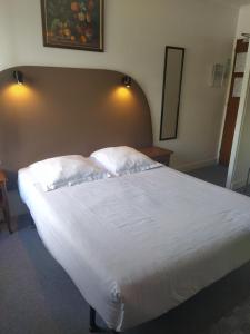 a bedroom with a large bed with white sheets and pillows at Le Nouveau Monde in Breuillet