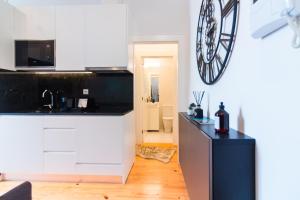 a kitchen with white cabinets and a black counter top at ON Apartments - Lapa Deluxe in Porto