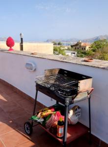 a grill sitting on a porch with a cart at Attico con terrazza sul porto in Palermo