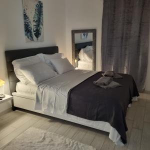 een slaapkamer met een bed met een zwarte deken en een spiegel bij Apartman Magnolija Umag in Umag