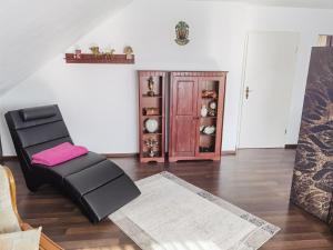 a living room with a black chair and a table at Ländliche Idylle in Hochfranken in Regnitzlosau